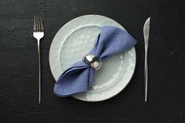 Çatal bıçak takımı, peçete ve tabağı koyu desenli masa, düz yatıyordu.