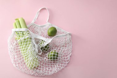 Kerevizli ip torbası ve pembe arka planda limon, üst manzara. Metin için boşluk