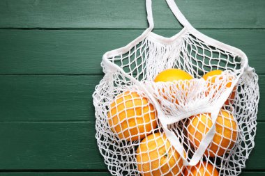 Yeşil ahşap masadaki portakallı torba, üst manzara. Metin için boşluk