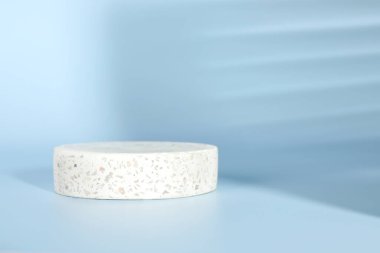 Ürünün sunumu. Açık mavi arka planda yuvarlak podyum ve gölgeler. Metin için boşluk