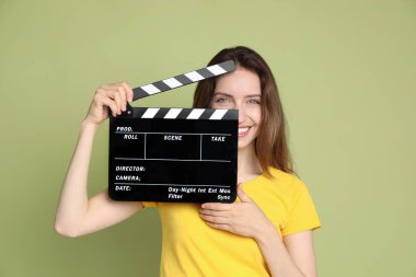 Film çekiyoruz. Yeşil arka planda alkışlarla gülümseyen kadın.
