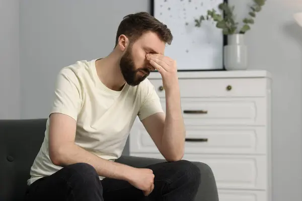 stock image Overwhelmed man suffering from headache at home