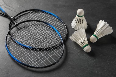 Tüylü badminton mekikleri ve raketleri gri desenli masa üzerinde