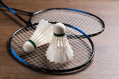 Tüylü badminton mekikleri ve raketleri ahşap masada yakın plan