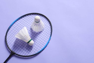 Menekşe arkaplanda badminton topları ve raket var. Metin için boşluk