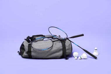 Tüy badminton mekik horozları, raketler ve çanta menekşe arka planda