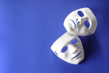 Tiyatro sanatları. Mavi arka planda beyaz maskeler, üst manzara. Metin için boşluk
