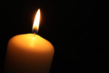 Siyah arka planda yanan bir kilise mumu, yakın plan. Metin için boşluk