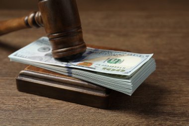 Tahta masada yığınla doları olan kanun tokmağı, yakın plan.