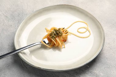 Gri masada çatal ve spagetti ile yapılmış bir kalp.
