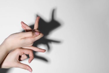 Gölge kuklası. Kadın arka plandaki tavşan gibi el hareketi yapıyor, yakın plan. Metin için boşluk