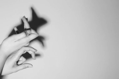 Gölge kuklası. Kadın arka plandaki tavşan gibi el hareketi yapıyor, mesaj için yeri olan bir yere yakın çekim yapıyor. Siyah ve beyaz etkisi