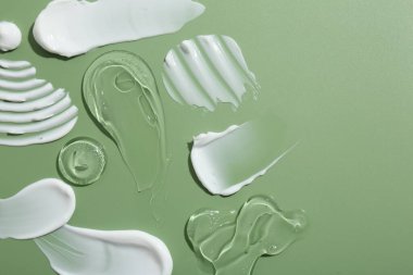 Yeşil arka planda yüz kremi örnekleri, üst manzara. Metin için boşluk