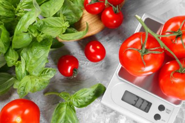 Mutfak terazisi domatesli ve fesleğenli gri desenli masa, düz.