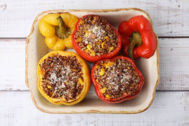 Lezzetli kinoa dolma dolma dolma dolma dolma biber ve mısır kabında beyaz ahşap masa, üst görünüm