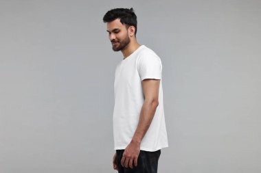 Yakışıklı adam gri arka plan üzerinde beyaz t-shirt