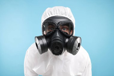 Açık mavi arkaplanda gaz maskeli bir işçi
