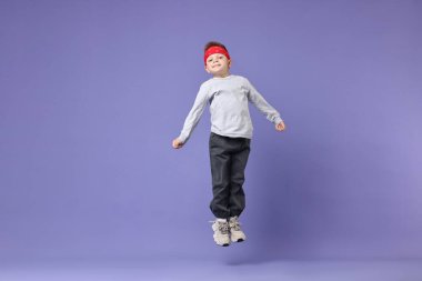 Küçük mutlu çocuk menekşe arka planda dans ediyor. Metin için boşluk