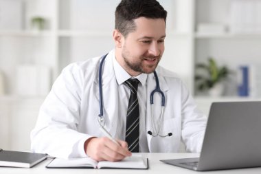 Doktorun klinikteki masada dizüstü bilgisayarla danışması