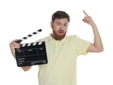 Film çekiyoruz. Clapperboard 'u beyaz arka planda bir şeye bakan adam.