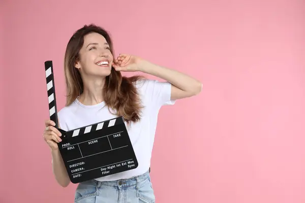 stock image Making movie. Smiling woman with clapperboard on pink background. Space for text