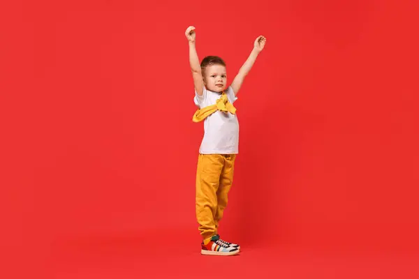 Stock image Happy little boy dancing on red background