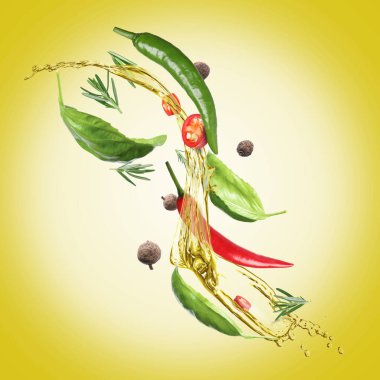 Altın arka planda kırmızı biber, fesleğen, biberiye ve tüm baharatla pişirme yağı sıçraması