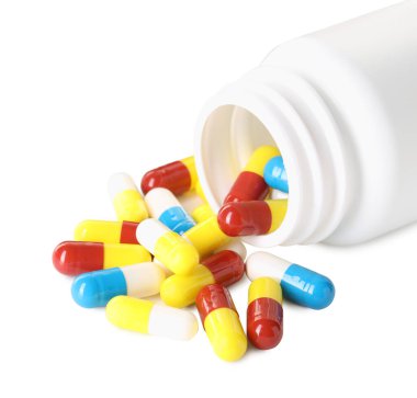 Dağılmış antibiyotik hapları ve beyaz şişeye izole edilmiş şişe.