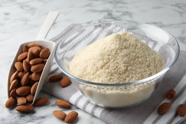 Taze badem unu, beyaz mermer masada kepçe ve fındık, yakın plan.