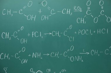 Yeşil tahtaya tebeşirle yazılmış kimyasal formüller.