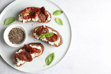 Nefis ricotta bruschettalar, güneşte kurutulmuş domatesler, fesleğen ve öğütülmüş biber. Metin için boşluk