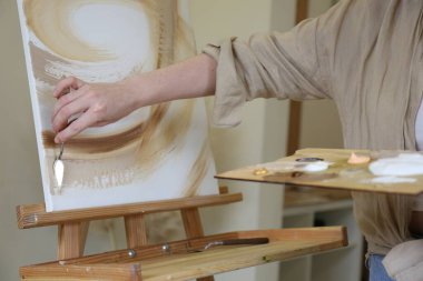 Paletli kadın stüdyoda resim çiziyor, yakın plan.