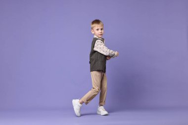 Küçük mutlu çocuk menekşe arka planda dans ediyor. Metin için boşluk