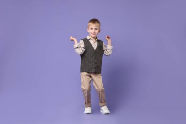 Mutlu küçük çocuk menekşe arka planda dans ediyor