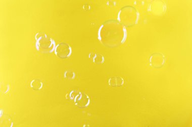 Sarı arka planda güzel şeffaf sabun köpükleri