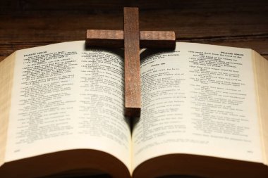 Bible and cross on table, closeup. Religion of Christianity clipart