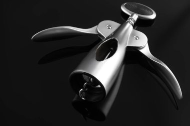 Koyu ayna yüzeyinde bir kanat tirbuşonu, yakın plan.