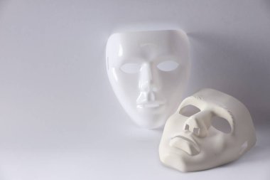 Beyaz arka planda plastik yüz maskeleri, metin için boşluk. Tiyatro performansı