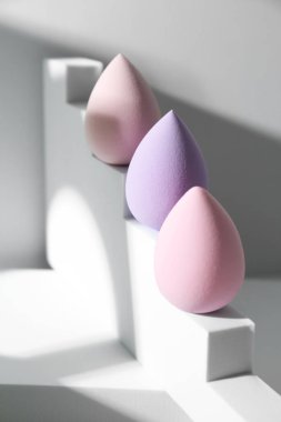 Beyaz arkaplanda makyaj süngerlerinin şık sunumu