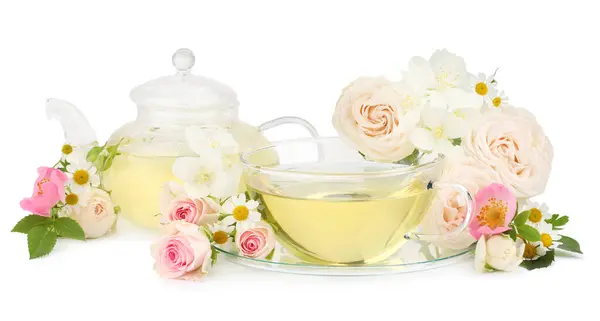 stock image Aromatic herbal tea in glass cup, teapot and flowers isolated on white