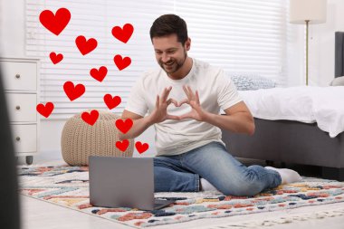 Uzun mesafeli ilişki. Adam içeride sevdiğiyle görüntülü konuşma yapıyor. Yanındaki kırmızı kalpler