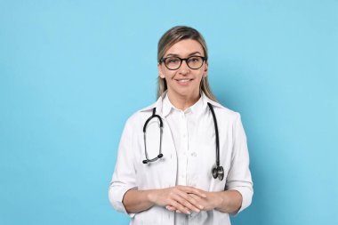 Açık mavi arka planda steteskoplu mutlu doktor portresi