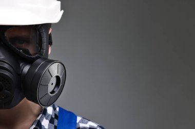 Gri arka planda gaz maskeli bir işçi, yakın plan. Metin için boşluk