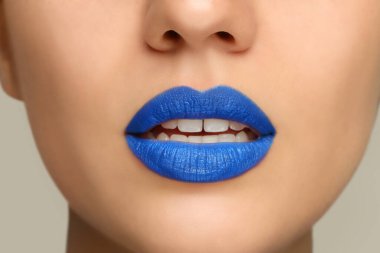 Açık arkaplanda mavi ruj süren kadın, yakın plan görüntüsü
