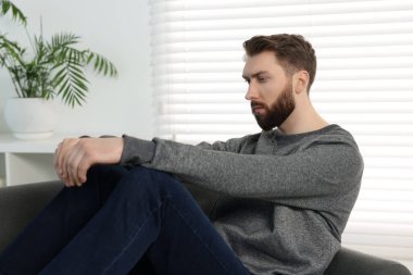 Yalnızlık kavramı. Evdeki kanepede oturan üzgün adam.
