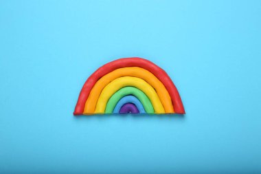 Açık mavi arkaplanda plastikten yapılmış güzel gökkuşağı, üst manzara