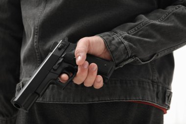 İçerde bir adam silah saklıyor, yakın plan. Silahlı soygun.
