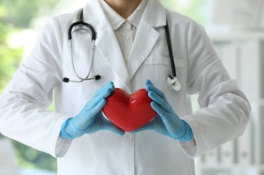 Klinikte kırmızı kalpli bir doktor, yakın plan.