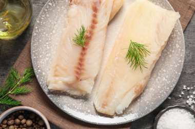 Çiğ morina balığı ve baharat parçaları masanın üstünde.