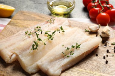 Çiğ morina balığı, mikro yeşillikler ve gri masadaki ürünler, yakın plan.